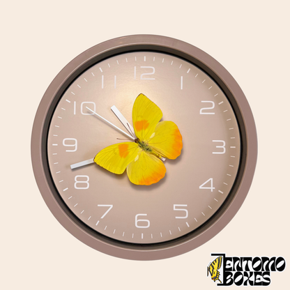 Horloge murale taupe avec un vrai papillon jaune (Phoebis philea) sur la trotteuse, vue de face