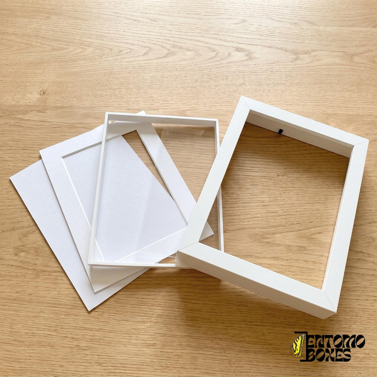 Shadow box frame taken apart: frame, clear plexiglass front, white mat and backing board